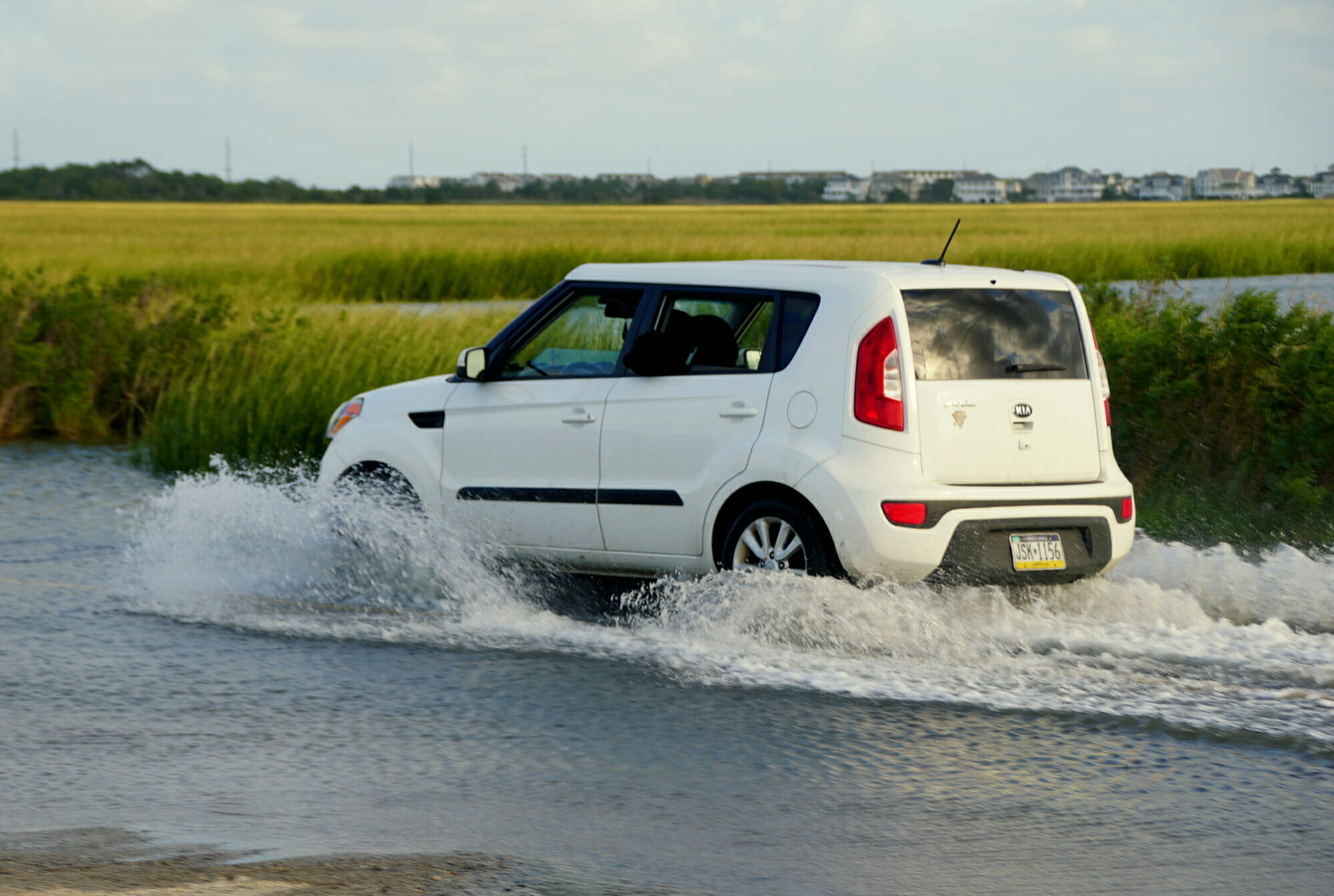 Kia Soul conduciendo a través del lecho del arroyo salpicando agua