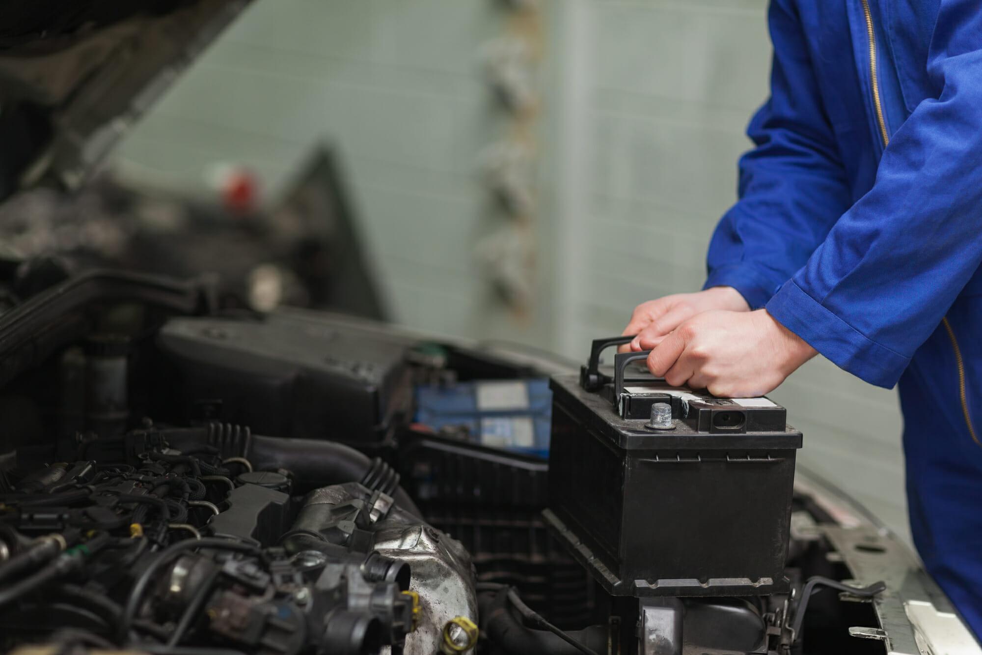 Mecánico de automóviles que cambia la batería del automóvil