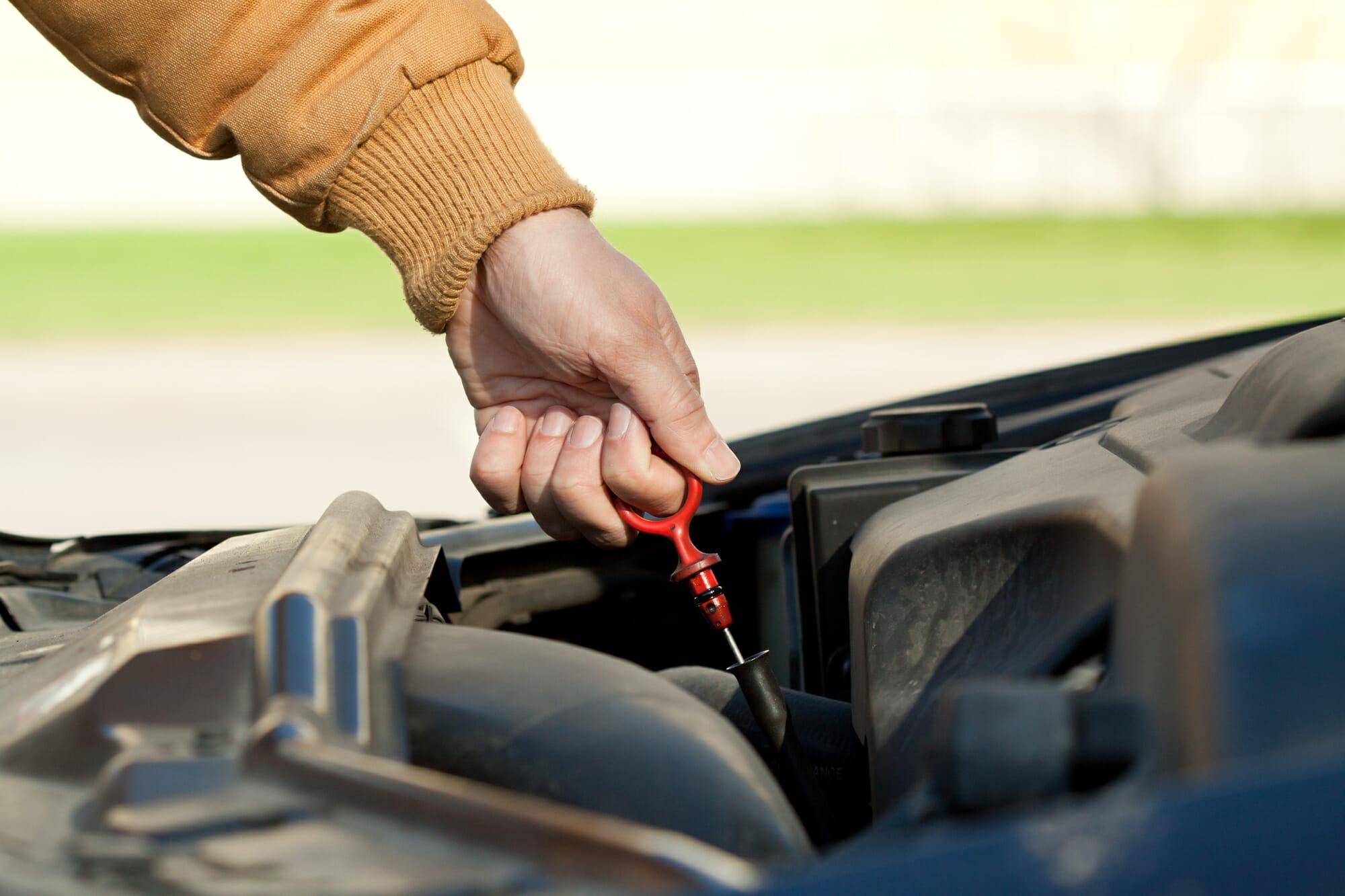Mecánico que comprueba el nivel de aceite del coche