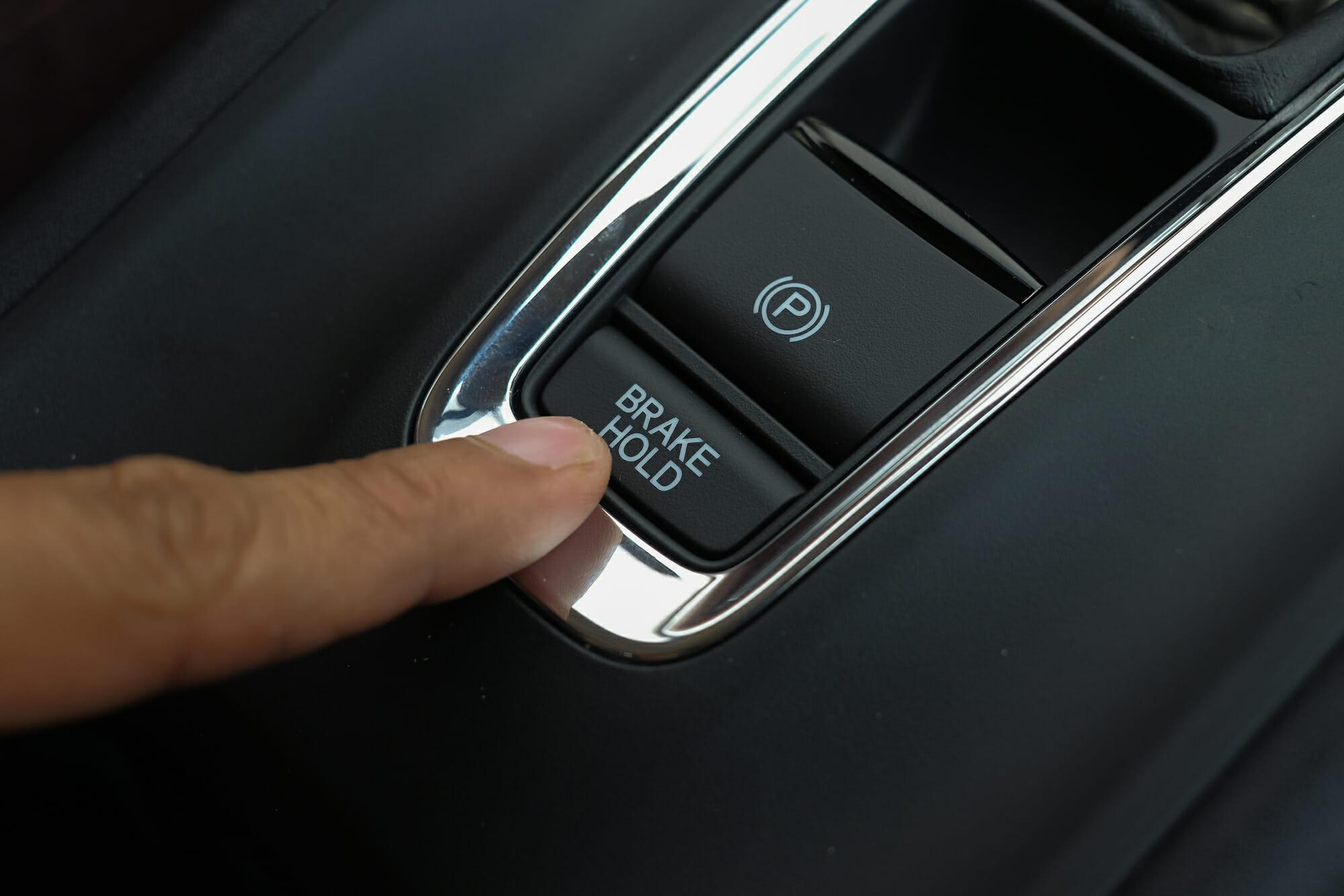 Primer plano del botón del freno de estacionamiento electrónico